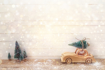 Wooden Toy Car with Christmas tree on the roof on a wooden table
