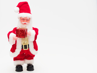 Toy Santa Claus holding a red gift box isolated on white background