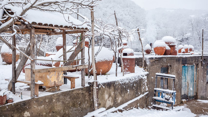 Snow covered georgian jugs for wine, outdoor in winter