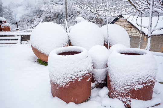 Snow covered georgian jugs for wine, outdoor in winter