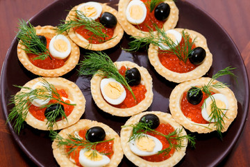 tarts shells with red caviar, egg and herbs