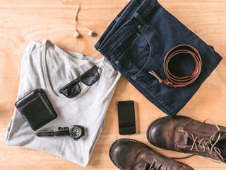 Top view of Men's casual outfits with accessories on wooden table