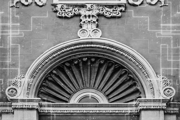 Detail of an old arch. Facade of an old building with a stucco molding.