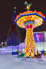 Winter carousel park forest snow. Christmas tree in the town square