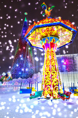 Winter carousel park forest snow. Christmas tree in the town square