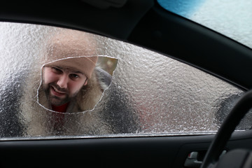 man broke the glass of the car a little stone