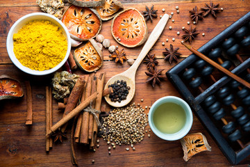 The composition with different spices and herbs on wooden table