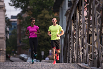 multiethnic couple jogging in the city