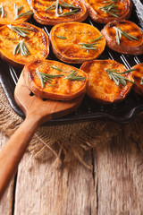 Roasted sweet potatoes with rosemary on the grill pan close-up. Vertical