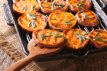 Roasted sweet potatoes with rosemary on the grill pan close-up. horizontal
