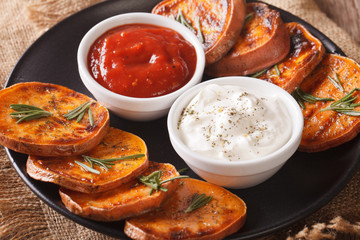 Grilled sweet potatoes with sour cream and ketchup closeup. horizontal