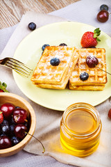 Waffles with berries on wooden background