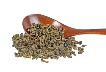 Dry green tea leaves in wooden spoon on white background