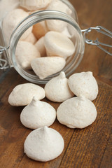 Coconut meringue in a glass jar on a wooden background.