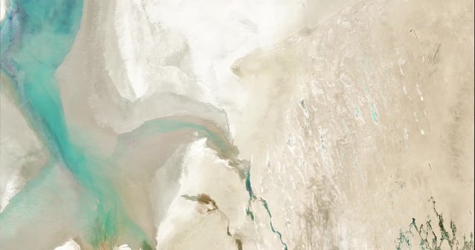 High-altitude overflight aerial of a nearly empty Aral Sea in Central Asia. Clip loops and is reversible. Elements of this image furnished by USGS/NASA Landsat 