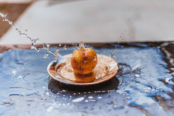 Fototapeta premium apples in the water stream standing on the plate outdoors