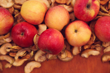 Свежие и сушеные яблоки на деревянном фоне