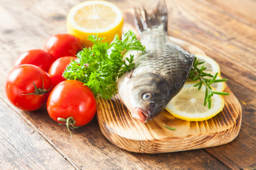fish with a lemon and tomatoes on a table, selective focus
