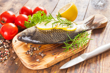 fish with a lemon and tomatoes on a table, selective focus