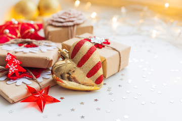 Christmas and New Year background with presents and decorative heart for Christmas tree. Holiday background with stars confetti and light bulbs. Place for text.