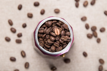 Italian moka pot full of roasted coffee beans. Top view