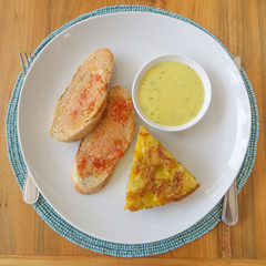 Top view of spanish potato tortilla, bread and sauce served on the plate