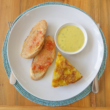 Top view of spanish potato tortilla, bread and sauce served on the plate