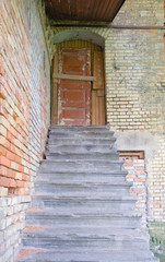 Old wooden house door with cracked stairs