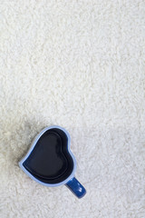 One blue cup in form of heart on the white fur background