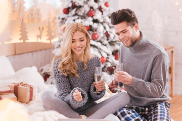 Delighted pleasant couple holding glasses of champagne