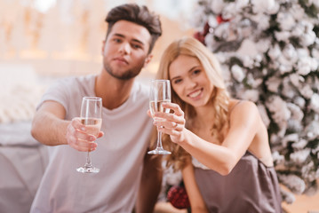 Delighted joyful couple holding glasses of champagne