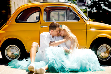 Man holds beautiful lady in dress with turquoise skirt while the - obrazy, fototapety, plakaty