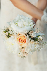 Bouquet of orange roses and large white flowers held by bride