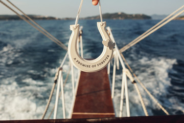 Wooden horseshoe with lettering 'A promise of forever' held over