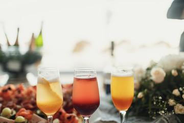 Champagne flutes with fruits stand on dinner table with snacks