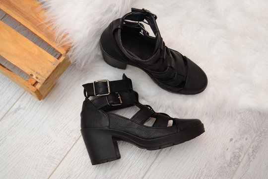 Fashion concept, black female shoes with buckles on the wooden box, space for text