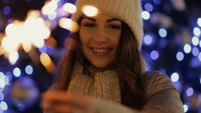 Happy young woman throws snow in air, slow motion. She enjoying winter.