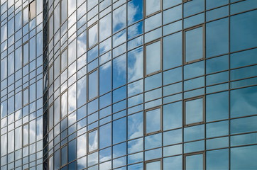 Plakat Skyscraper mirror glass surface reflecting cloudy sky, curvy surface