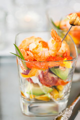 Shrimp, avocado, tomato, salmon and red caviar cocktail salad in