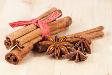 Cinnamon sticks and anise stars on wooden plank