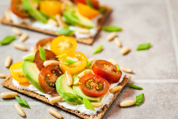 Сrisp bread toast  with cream cheese, fresh avocado, cherry tom