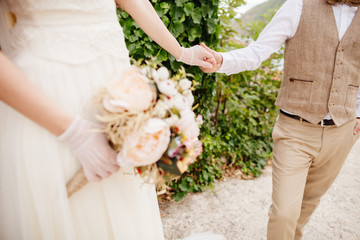 newlyweds holding wedding bouquet