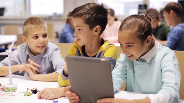kids with tablet pc programming at robotics school