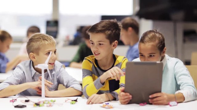 kids with tablet pc programming at robotics school