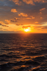 Sunset over ocean with reflection of sun on waves of atlantic ocean.