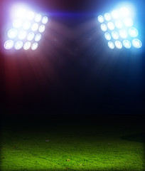 Green soccer field, bright spotlights, illuminated stadium © Kalawin
