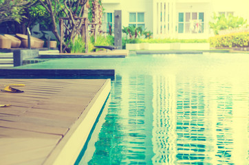 Outdoor swimming pool with blue water near the garden.