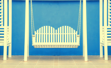 white wood swing on blue background , vintage tone photo