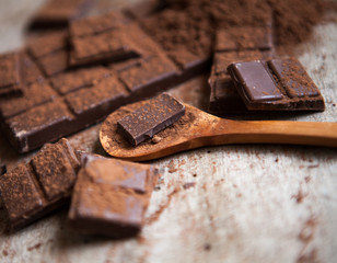 Dark chocolate stack, chips and powder.chocolate over wooden bac