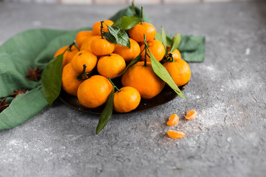 orange tangerines in bowl on gray background